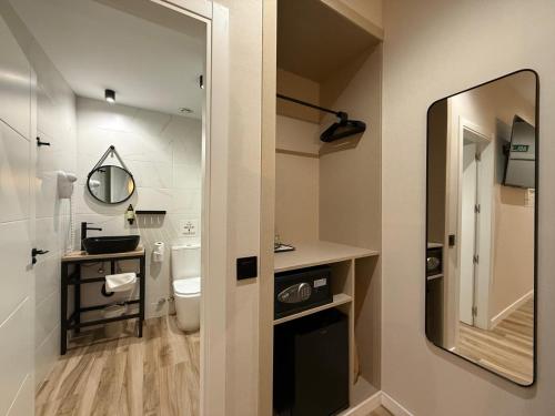 a bathroom with a toilet and a sink and a mirror at CC Opera Suites in Madrid