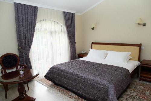 a bedroom with a bed and a large window at Prima Villa Guest House in Vinnytsya