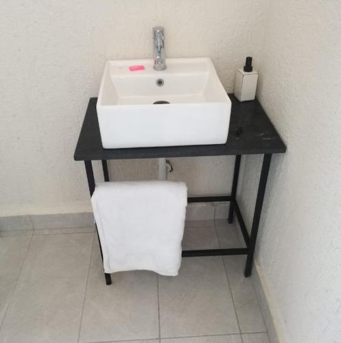 a bathroom with a white sink on a black counter at Halle Hotel - Lalibela in Lalībela