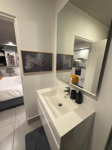 a bathroom with a sink and a mirror and a bed at Sibaya's Premium Apartment in Coral Point in Sibaya
