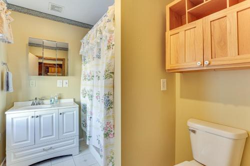un baño con inodoro y lavabo en Historical Log Cabin on 80 Acres in Hartford!, en Hartford