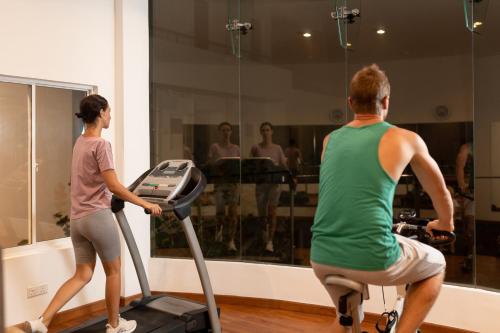 a man and a woman riding a treadmill in a gym at Oceanfront Galle by ICC in Galle