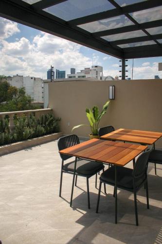 a wooden table and chairs on a patio at Lasai Casa Tonala in Mexico City