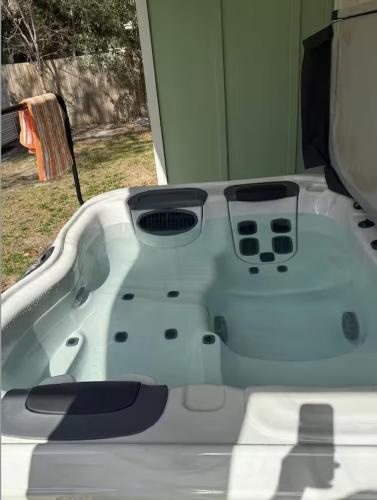 a white bath tub sitting in front of a window at Nirvana Nature's Nook in Palm Coast