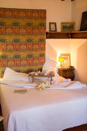 a bedroom with a white bed with a table on it at La Magione dei Todaro in Borgo a Buggiano