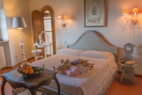 a bedroom with a bed with a bowl of fruit on it at La Magione dei Todaro in Borgo a Buggiano