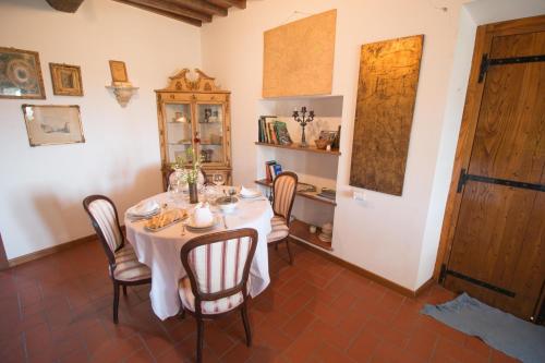 a dining room with a white table and chairs at La Magione dei Todaro in Borgo a Buggiano
