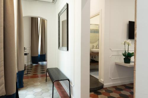 un corridoio con specchio e sedia in una stanza di Nox a Roma