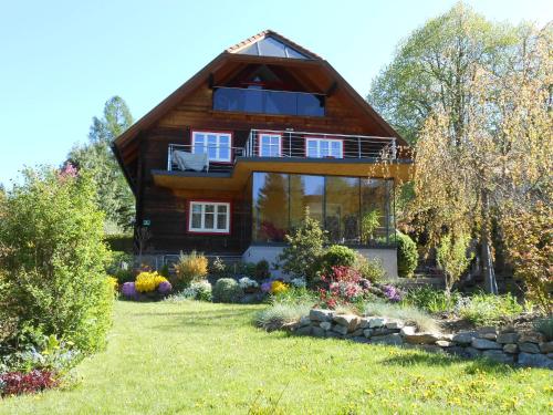 a wooden house with a garden in front of it at Willa auf der Steinplatte in Teufenbach
