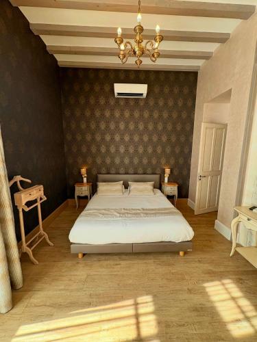 a bedroom with a large bed and a chandelier at Château Pellisson in Cognac