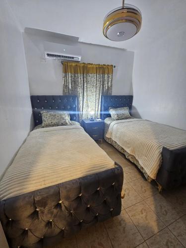 a bedroom with two beds and a window at Mar & Brisa Apartamento Frente al Mar con Lujo y Confort in Los Mameyes