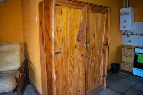 una puerta de madera en la esquina de una cocina en Turismo Aparts Cabaña 3 Monoambiente, en Villa Giardino