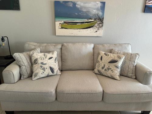 a couch with pillows and a yellow boat on a beach at Aguada Beach Condos in Aguada