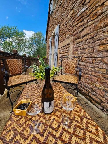 - une bouteille de vin assise sur une table avec des verres à vin dans l'établissement Le Moulin de Chazelle, à Cormatin