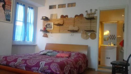 ein Schlafzimmer mit einem Bett mit einer lila Decke in der Unterkunft B&B 104 in Blevio