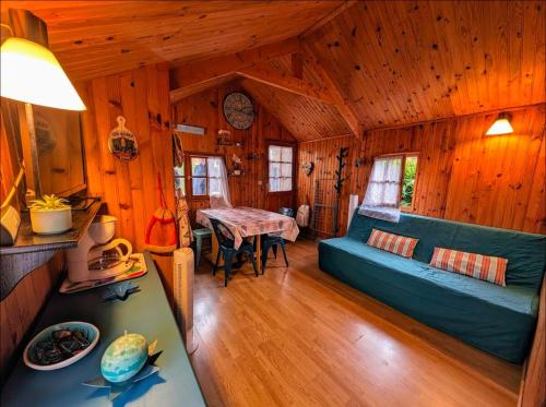 una habitación con una cama y una mesa en una cabaña en Le petit chalet de Cabourg, en Cabourg