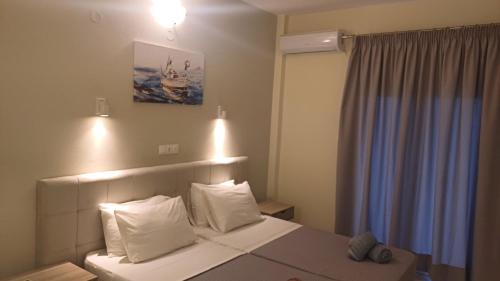 a hotel room with a bed with white pillows at Villa Kavourakia in Kolios