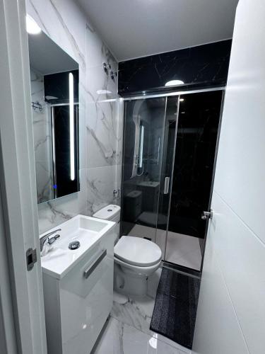 a white bathroom with a toilet and a sink at TAJ house center altea #1 in Altea