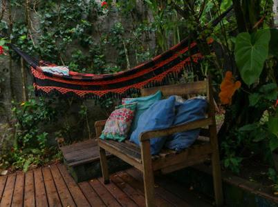 a wooden bench with pillows sitting on a deck at Flor da ilha in Ilha de Boipeba