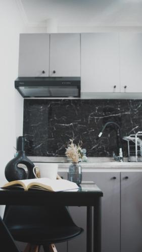 a kitchen with a table with a book and a stove at Departamentos Santa Bárbara Osorno in Osorno