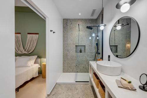 een badkamer met een wastafel, een douche en een bed bij Six keys in Ermoupoli