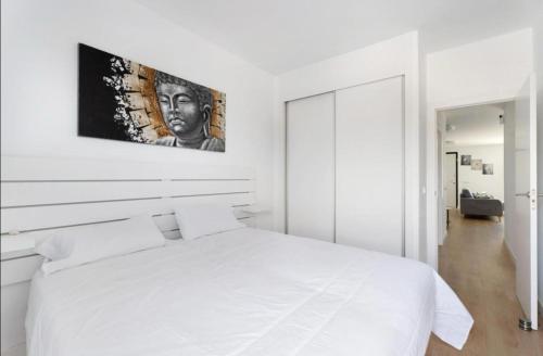 a white bedroom with a white bed with a picture on the wall at Abades confort & luxury in Abades