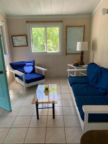 a living room with a blue couch and a table at Secluded Tropical Escape, close to English Harbour in Cobbs Cross