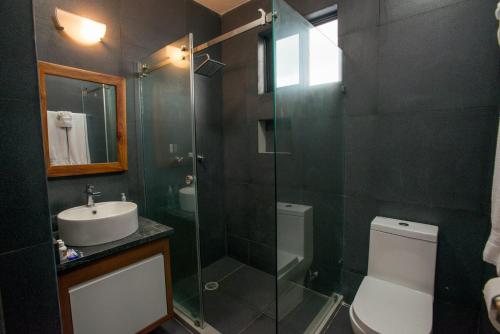 ein Badezimmer mit Dusche, Toilette und Waschbecken in der Unterkunft Casa de Mario 4 Beautiful house with a huge pool in Cozumel