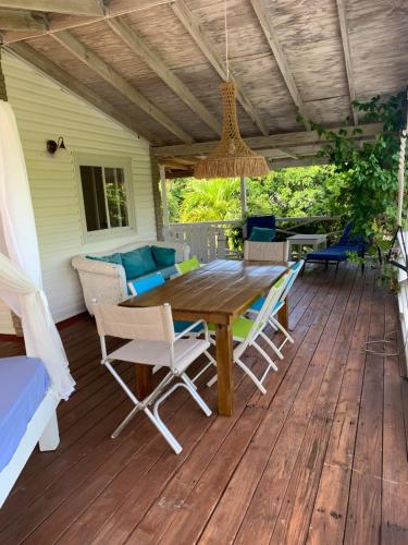 a wooden table and chairs on a deck at Secluded Tropical Escape, close to English Harbour in Cobbs Cross