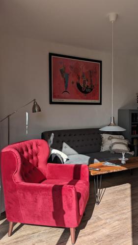 a living room with a red couch and a table at Ferienwohnung im Kontor Penzlin in Penzlin
