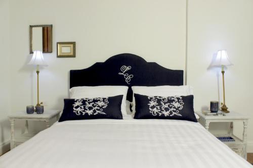 a large white bed with black and white pillows at Leclerc Hotel Boutique Cali Granada in Cali