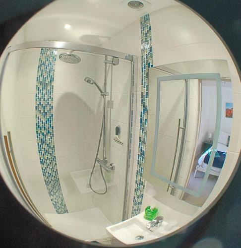 a bathroom with a shower and a sink in a mirror at Goviers Cottage in Sidmouth