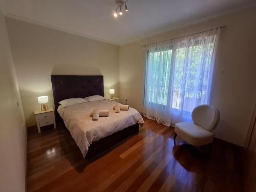 una camera da letto con un letto grande e una grande finestra di Cozy and Bright Apartment a Machico