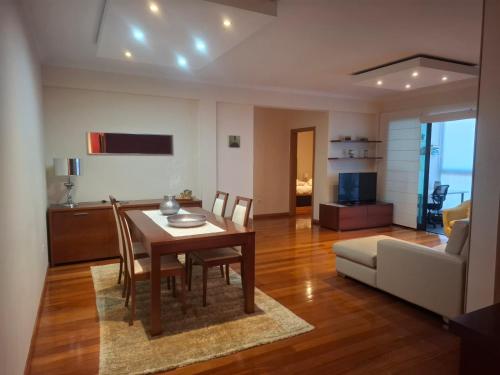 un soggiorno con tavolo, sedie e divano di Cozy and Bright Apartment a Machico