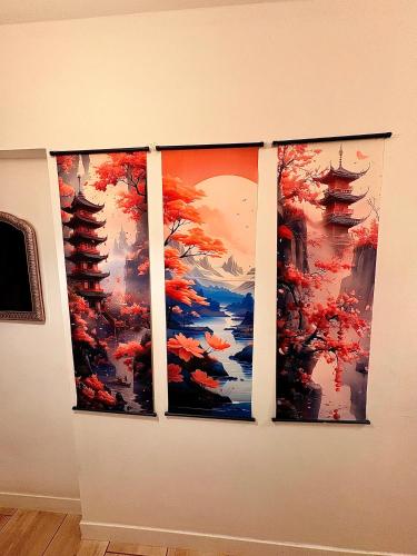 Trois œuvres d'art sur un mur dans l'établissement Le Nid Thermal, à Royat