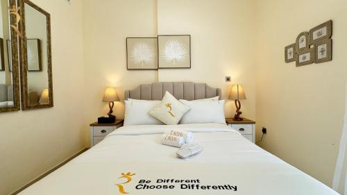 a bedroom with a large white bed with two lamps at 1BR Al Reem - Chic Comfort Cove Retreat in Abu Dhabi