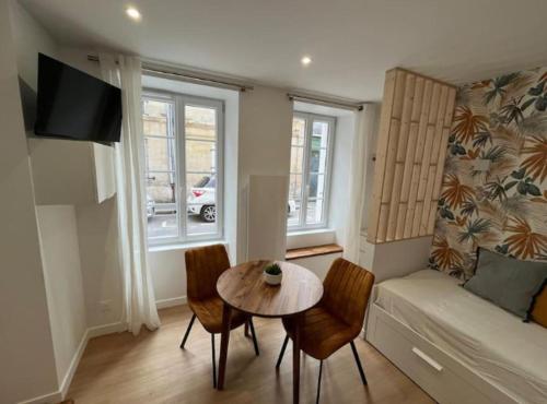 un salon avec une table, des chaises et un canapé dans l'établissement Le Petit Saint-Martin - Hypercentre, à Caen