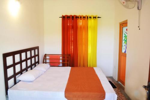 una camera da letto con un letto con una tenda colorata di Pelican View Cottages a Kataragama