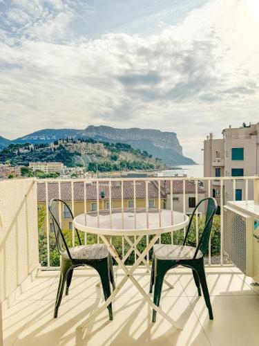 une table et deux chaises sur un balcon avec vue dans l'établissement Petit Cocon - Parking - Climatisation - Wifi, à Cassis