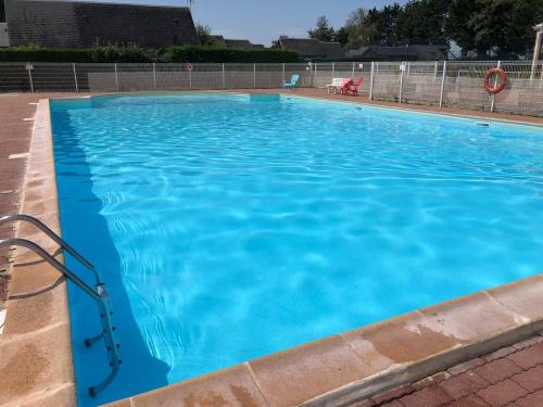 una gran piscina con agua azul en Le petit chalet de Cabourg, en Cabourg
