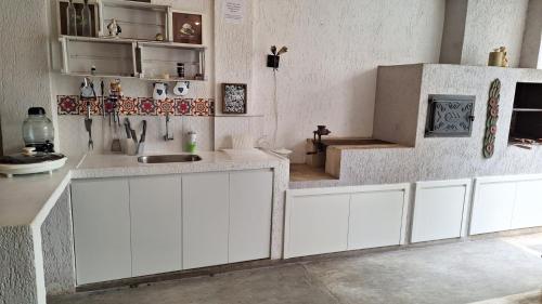 a kitchen with white cabinets and a sink at Casa Alto Da Boa Vista Com Piscina e Churrasqueira in São Paulo
