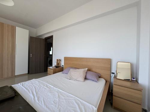 a bedroom with a large white bed with purple pillows at Previllage Red Apartments 7-8 in Kos Town
