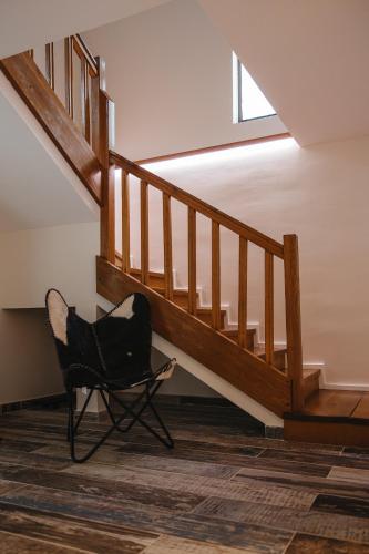 a black chair in a room with a staircase at Acasa la Pojorata in Pojorîta
