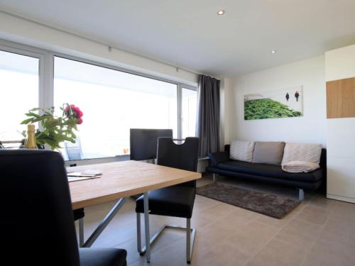 a dining room with a table and a couch at Wangerooge sea view Comfortable Vacation Home in Wangerooge