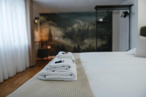 two towels sitting on a bed in a room at Acasa la Pojorata in Pojorîta