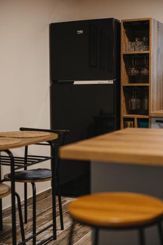 a kitchen with a black refrigerator and tables and chairs at Acasa la Pojorata in Pojorîta