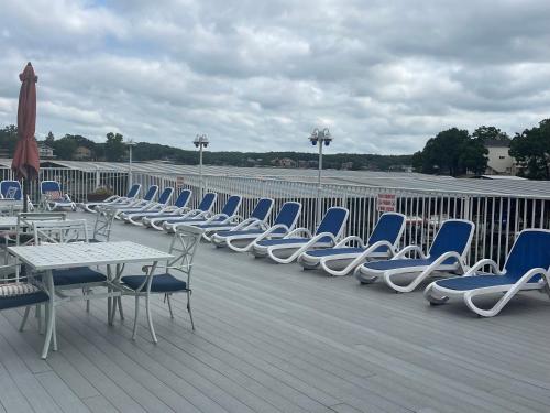 a row of chairs and tables on a deck at STAIRS OPTIONAL! Lakefront! Pool! On Water! Convenient Fishing! in Osage Beach