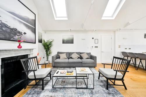 a living room with a couch and a fireplace at Spacious Fitzrovia Apartment 3 Bed in London