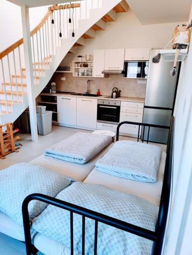 two beds in a kitchen with a staircase at Pod Dubem in Veselá