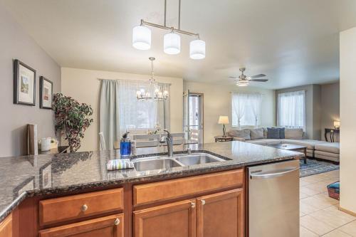 a kitchen with a sink and a living room at Walk to Downtown Leavenworth * Sleeps 6 + Pets * Ground Level Gem! in Leavenworth